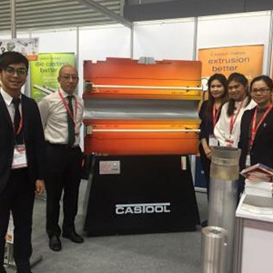 A group stands smiling beside a CasTool products.