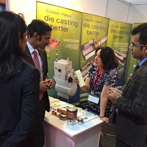 A woman explains products to a group of people at a trade show.